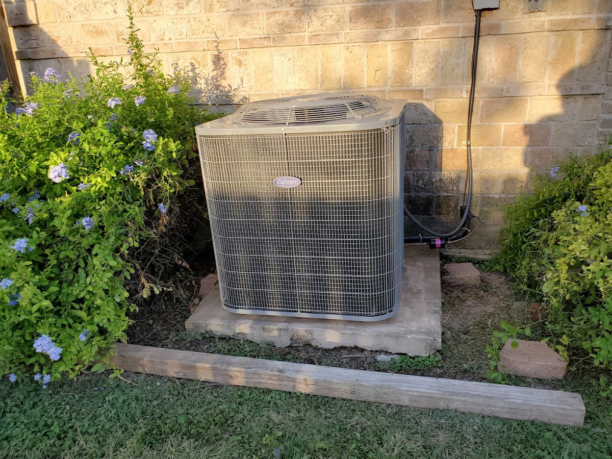Carrier A/C condenser installed beside a Harlingen home